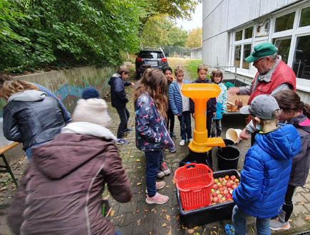 Schüler Äpfel pressen und einen Saft herstellen