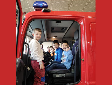 Besuch bei der Feuerwehr - Schüler im Feuerwehrauto