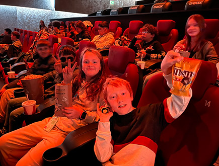 Schüler im Kino mit Popcorn und Nachos